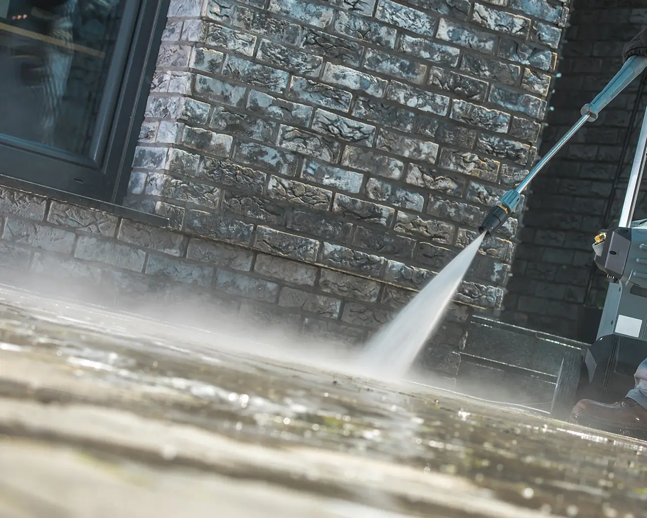 Pressure washing a concrete patio with a Power washer.